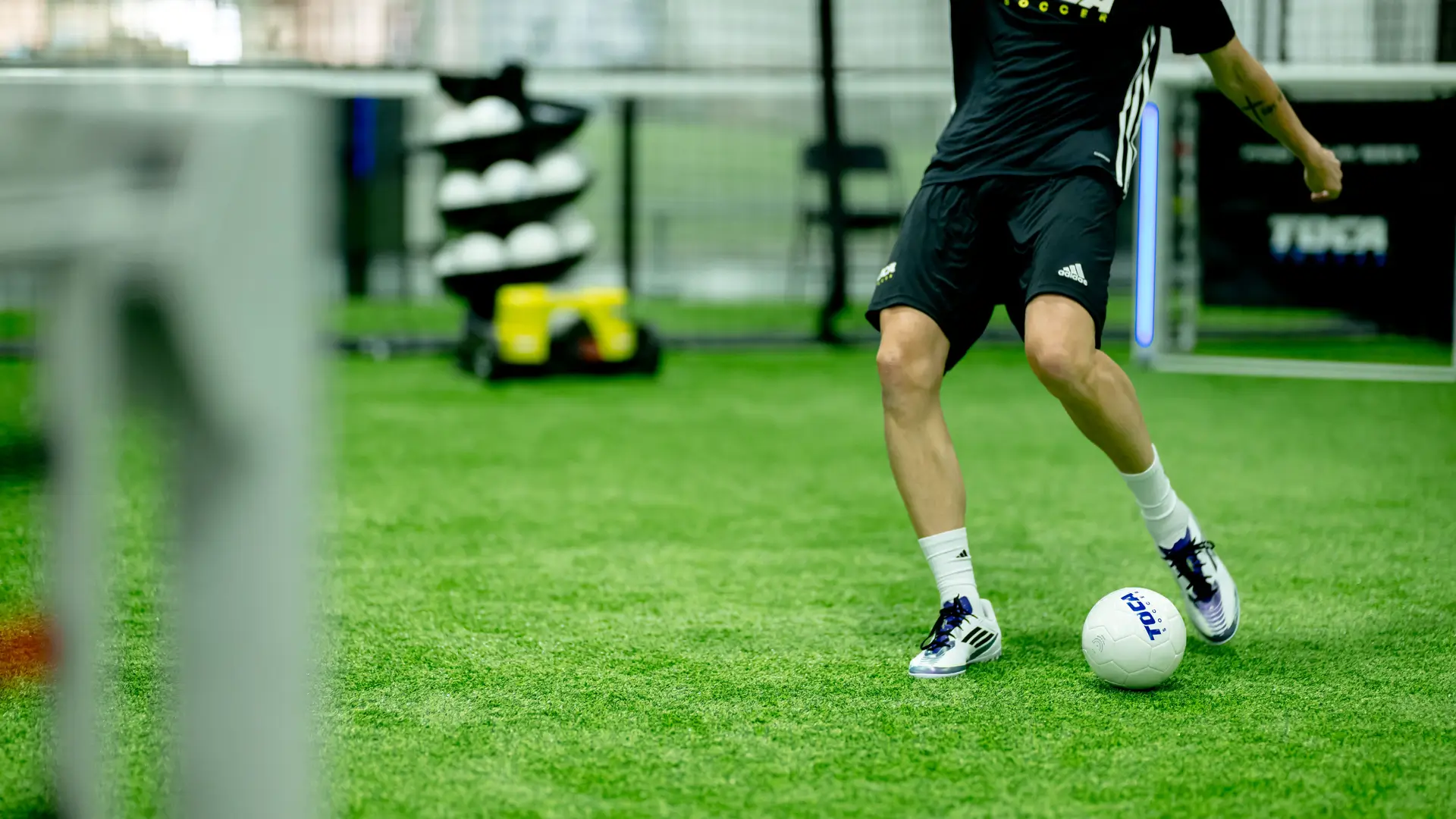 Soccer player controlling a ball on indoor turf at a TOCA Soccer training facility