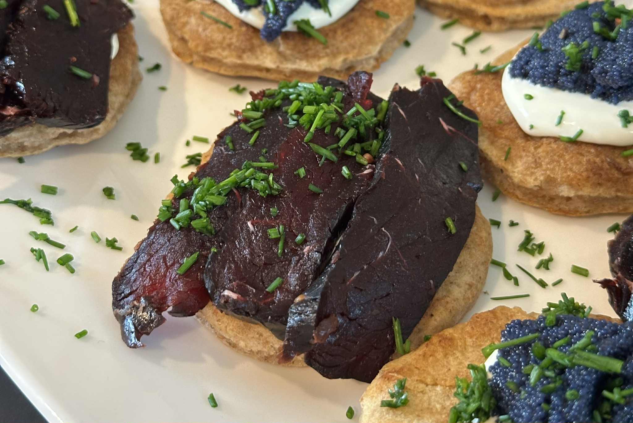 Blini med røkt hval, rømme og gressløk