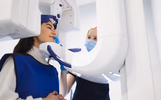 Zahnärztin setzt Patientin für ein 3D-Röntgenbild mit einem DVT auf.