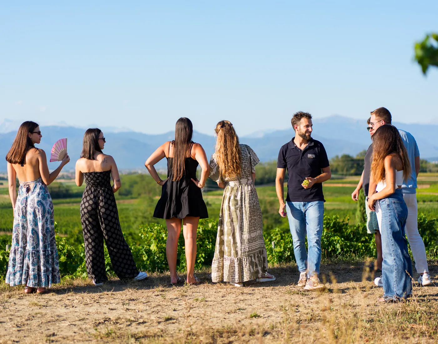 A group of visitors among the vineyards of the Colli Orientali del Friuli with their Ermacora guide, with the mountains in the background
