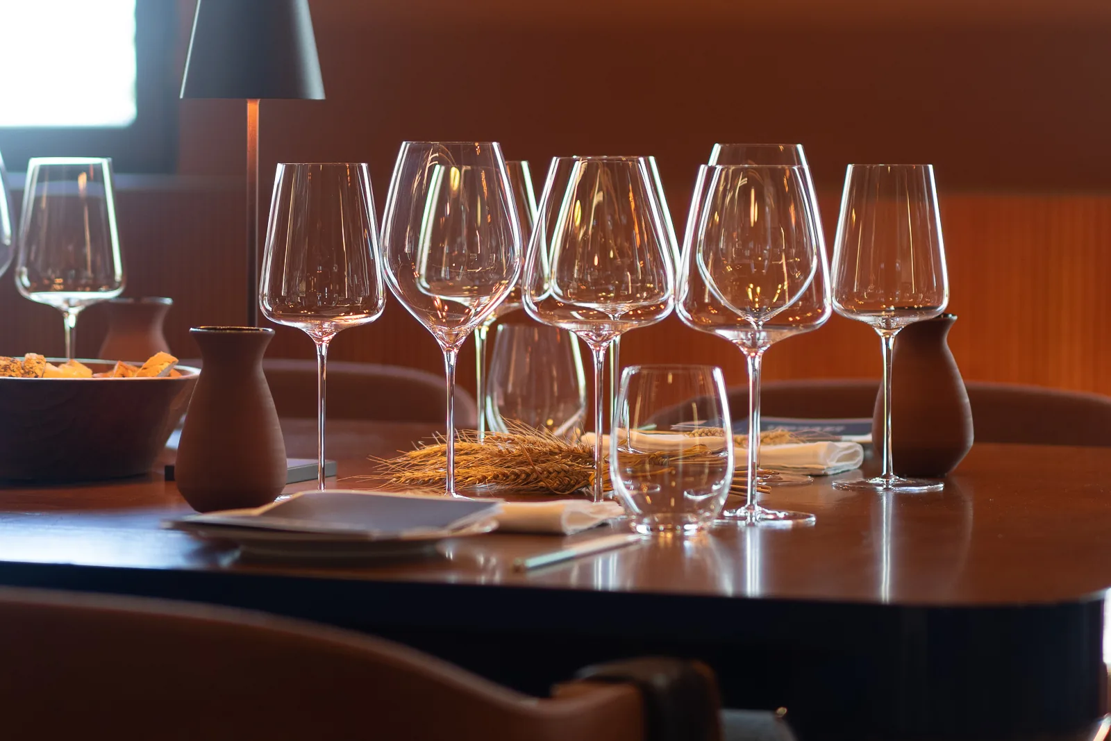 Calici allineati sul tavolo di legno della sala degustazione, pronti per la visita
