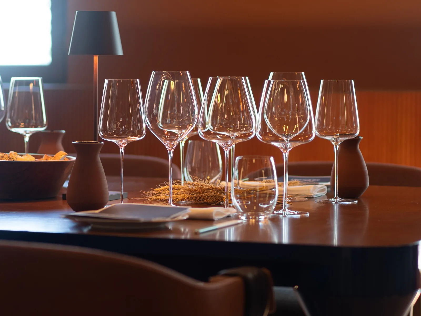 La sala degustazione apparecchiata con i calici e le spighe di grano sul tavolo