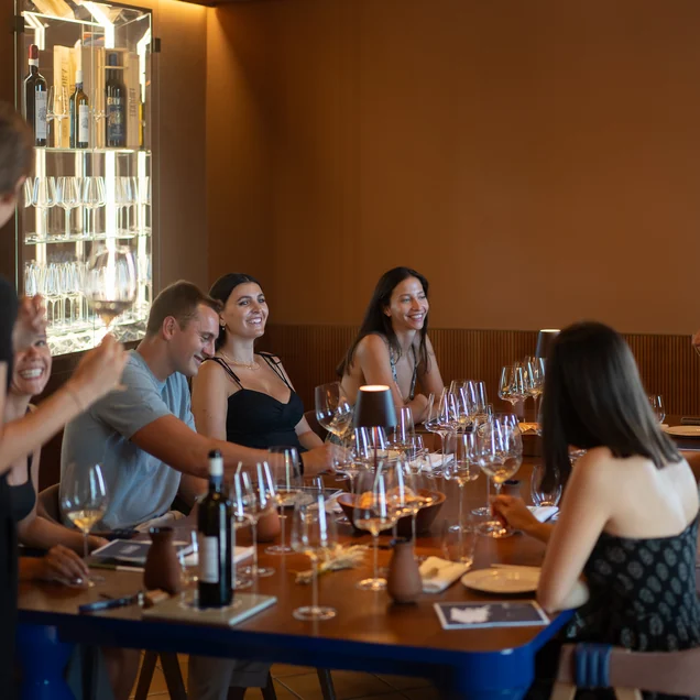 Degustazione di gruppo a tavola nella sala della cantina Ermacora