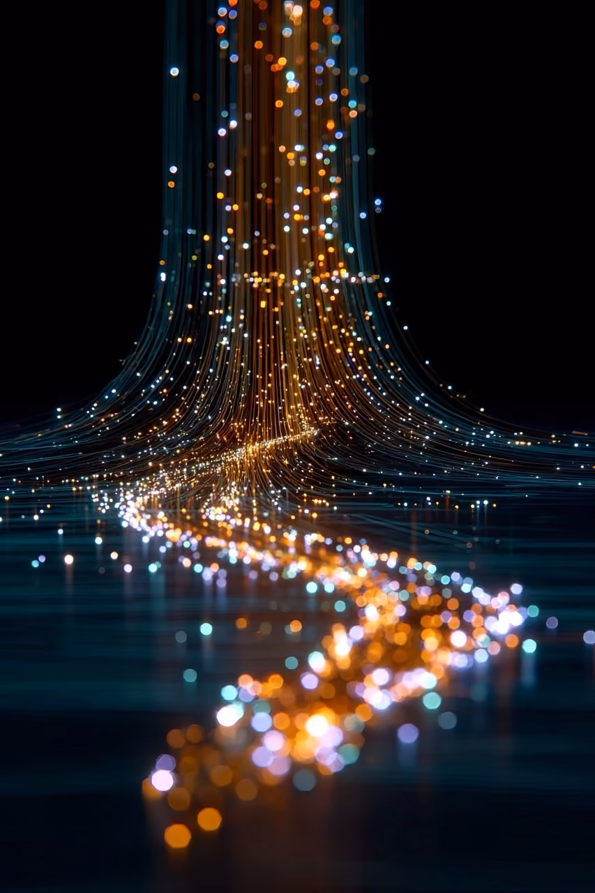 Curved strands of glowing orange and blue lights streaming down in a dark space.