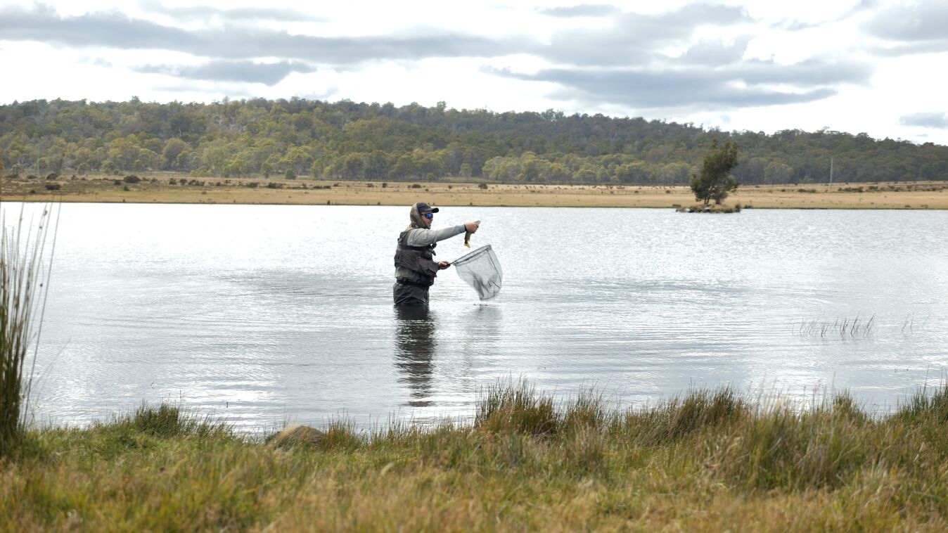 matt in water holding up a fish