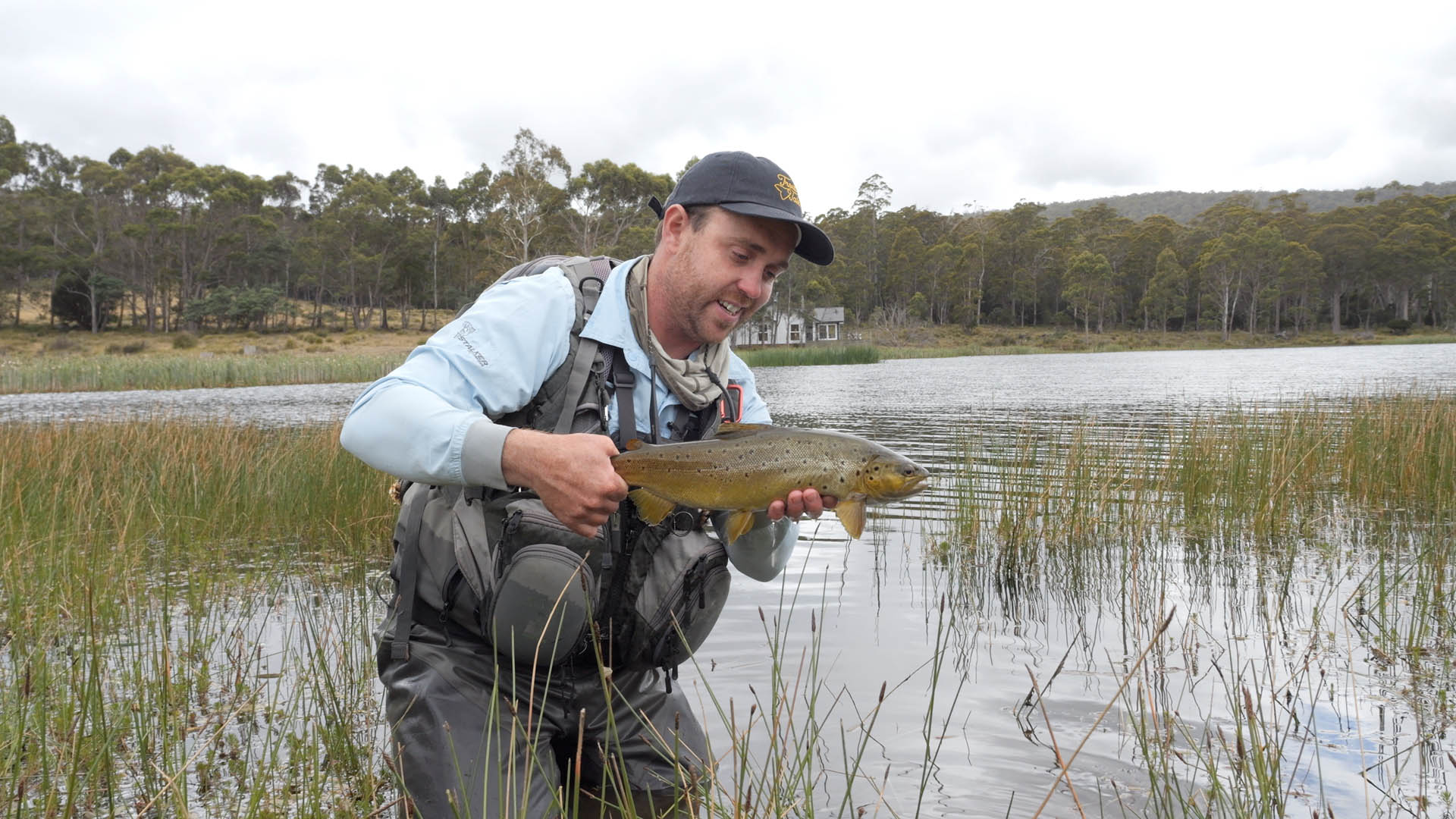 matt in blue top and cap holding trout at currawong lakes