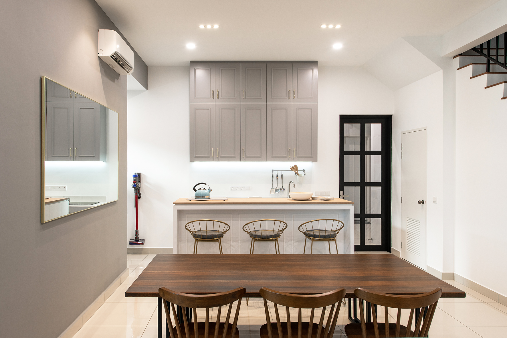 Dining area with organic solid timber dining table overlooked by a small Dry Kitchen island.