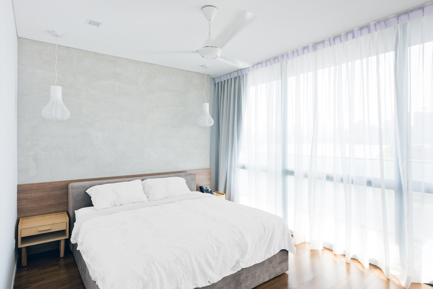 Minimalist master bedroom with cement render finish on the headboard