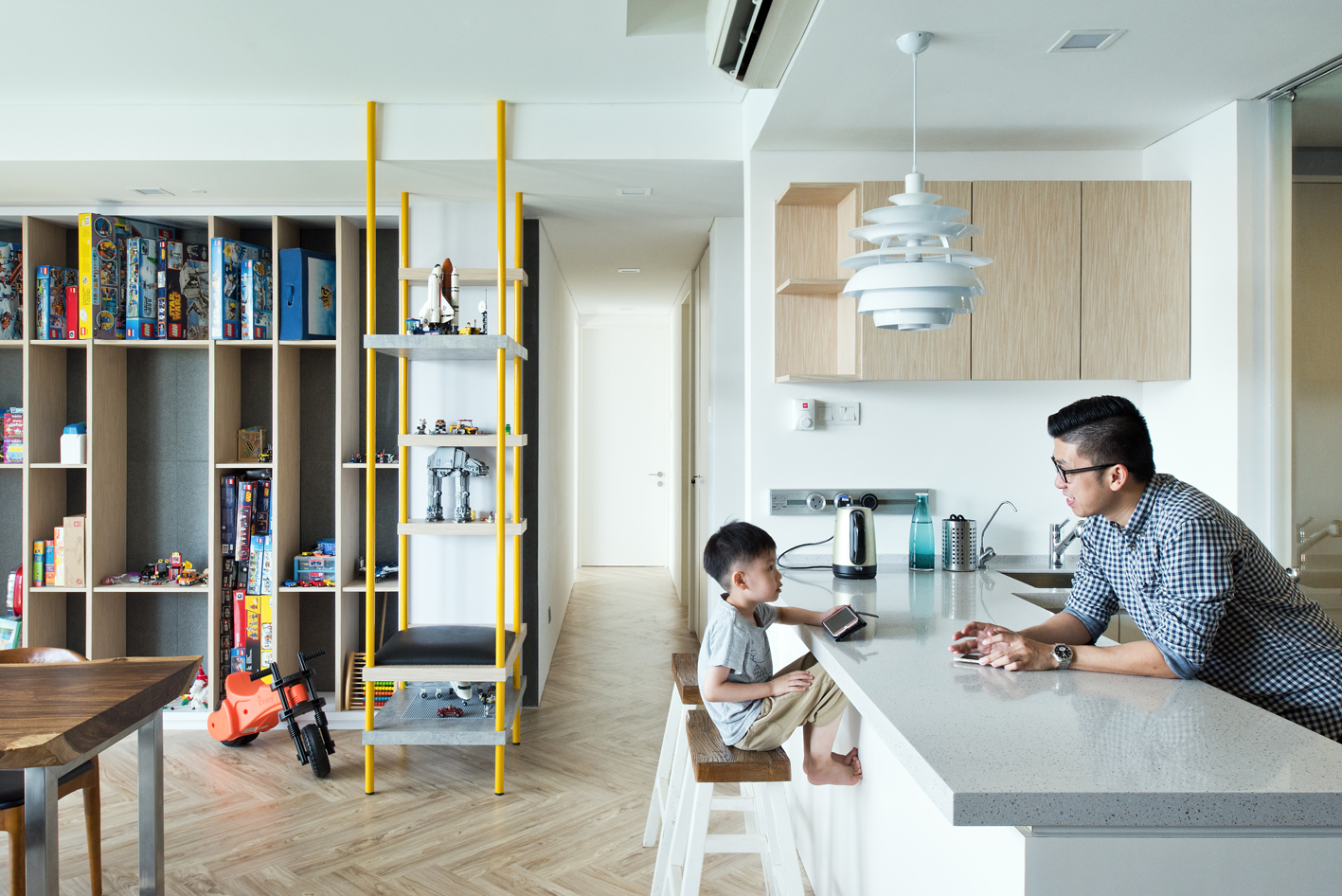 Father and son having a conversation over the kitchen island. Kids toys display in the background