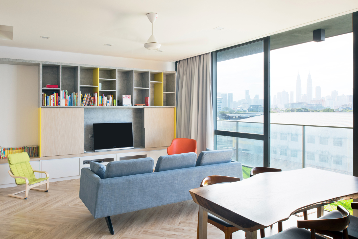 Open living room with sliding door to conceal TV. View of KL city centre. in the background