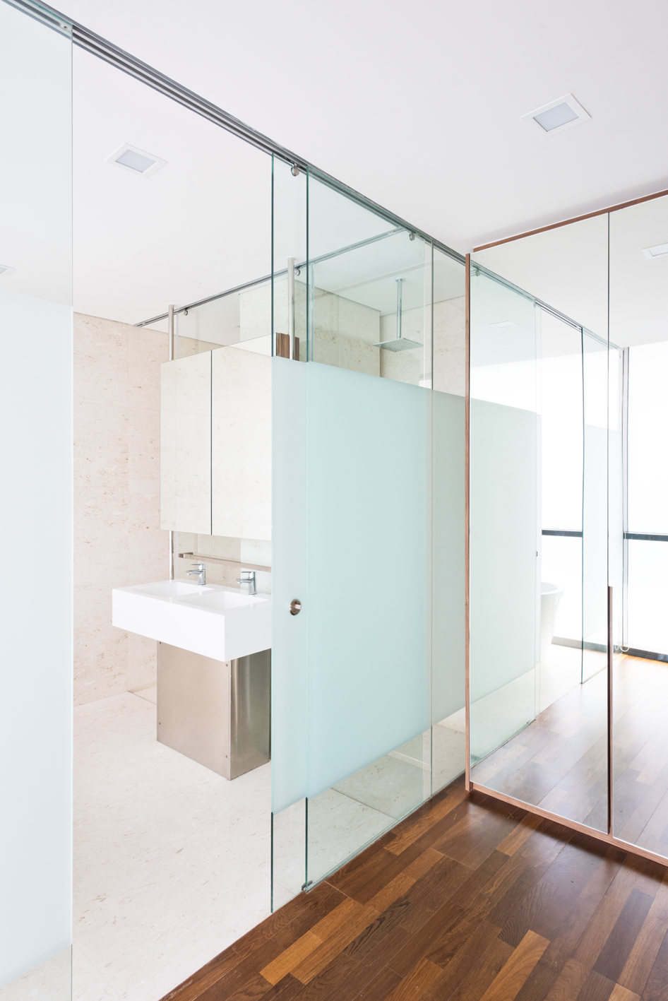 Master bath with glass doors next to walk in closet