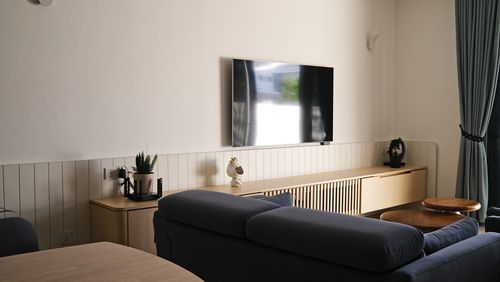 A cozy living room with a wall-mounted TV.