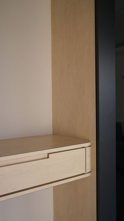 A corner shelf with a drawer in a room.