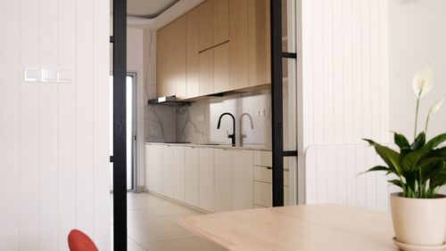 A kitchen with a wooden table and four chairs arranged neatly in the center.