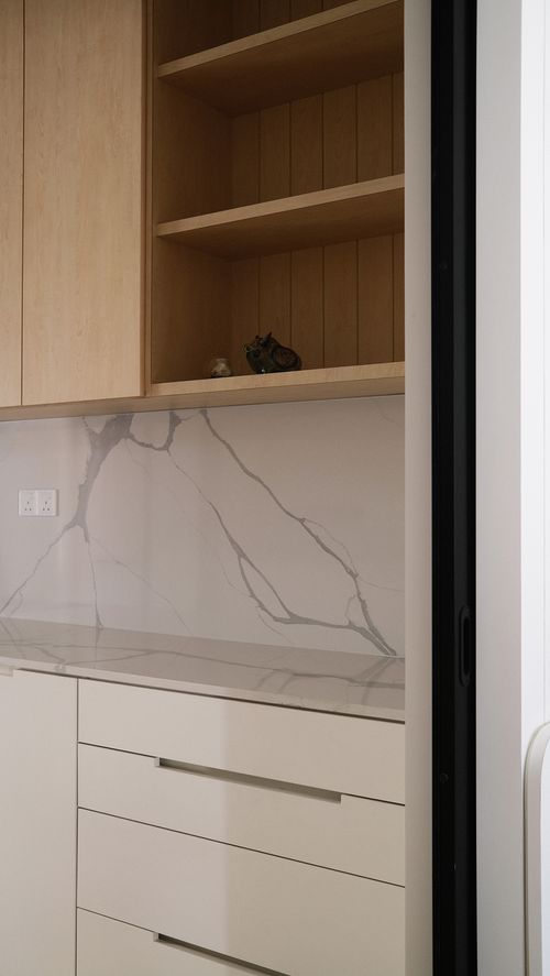 A white kitchen base with stone countertop and backsplash