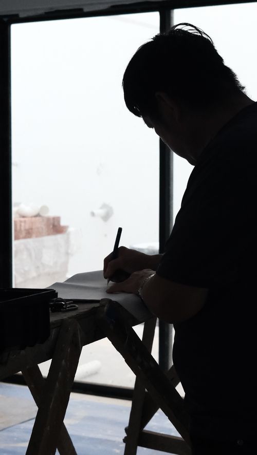 Silhouette of a man jotting down notes on a construction site