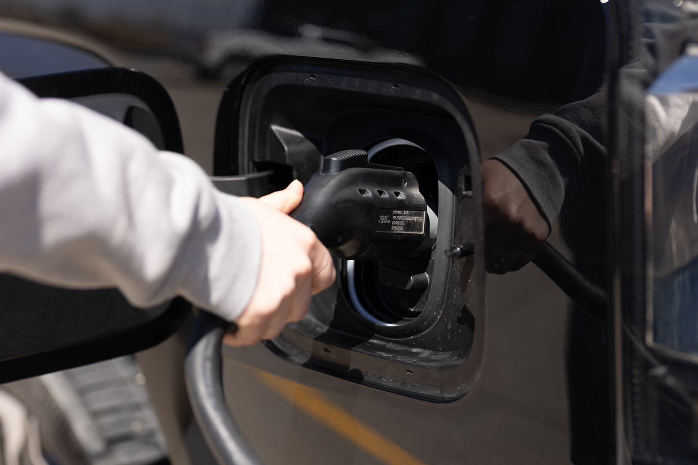 A closeup of a person charging a Chevy EV truck