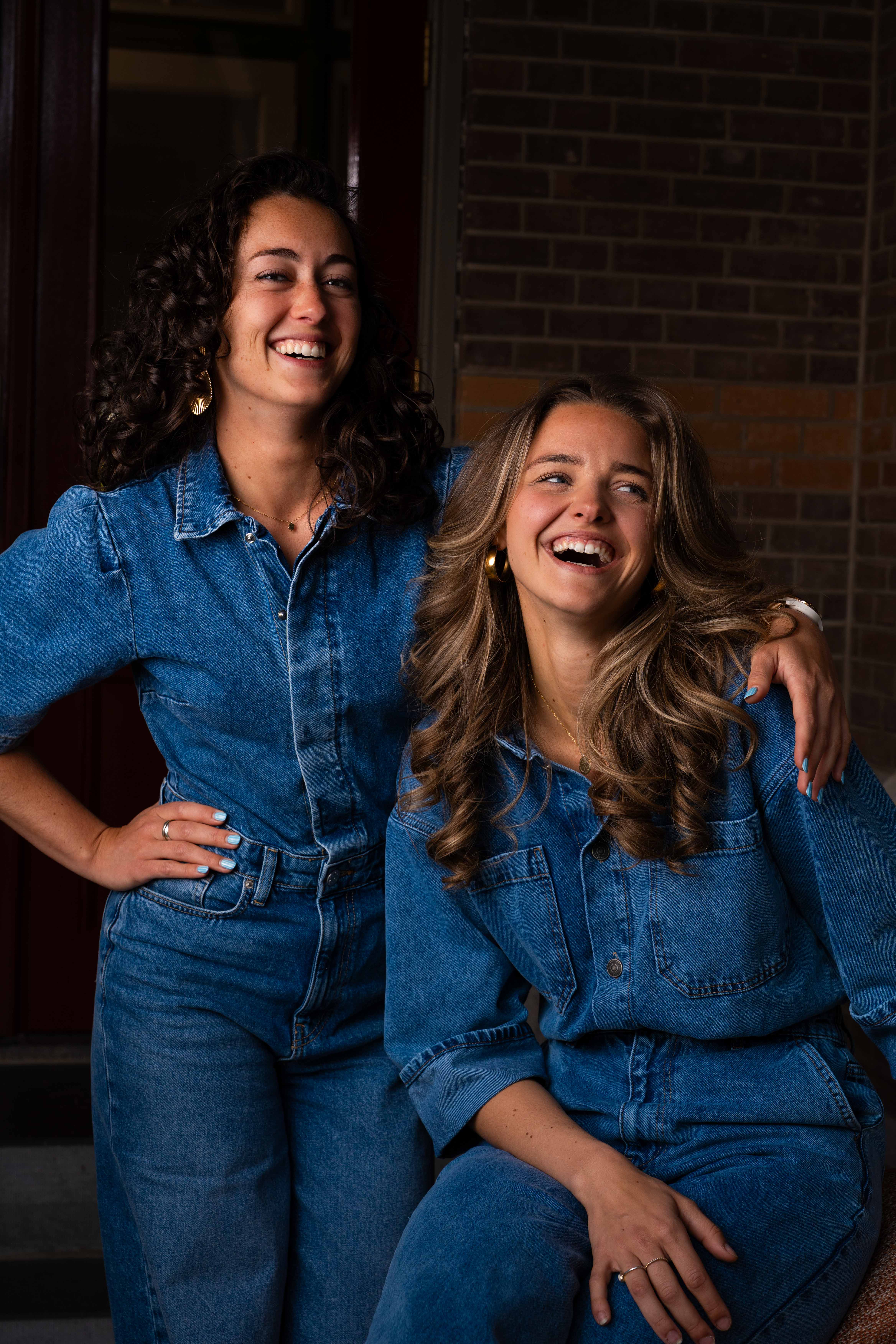 Hannah en Michelle lachen samen en stralen een warme, ontspannen teamsfeer uit.