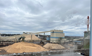 Une usine avec des piles de boisDescription générée automatiquement