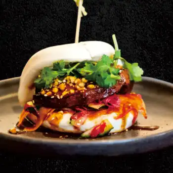 Slow-roasted pork belly and spring mix in a steamed bun with crushed peanuts and house special sauce