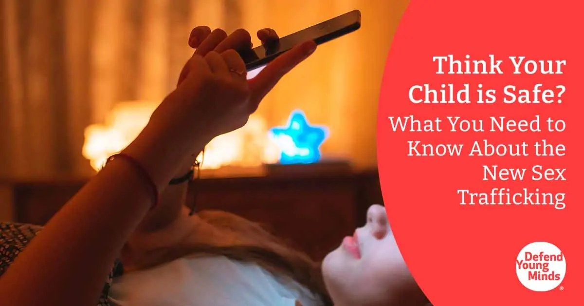 Image of a girl laying on her bed looking at a cell phone.