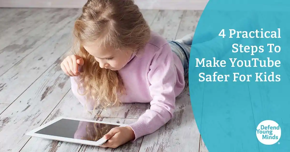 Young girl laying on the floor looking at an smart device.