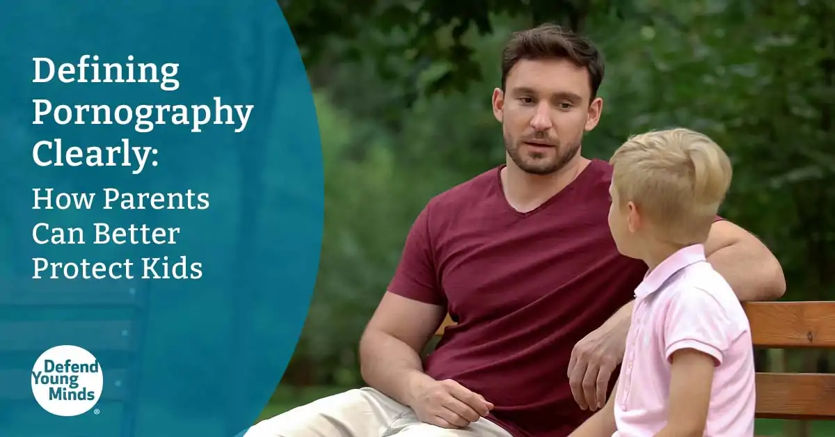 A father sitting with his son on a bench outdoors.