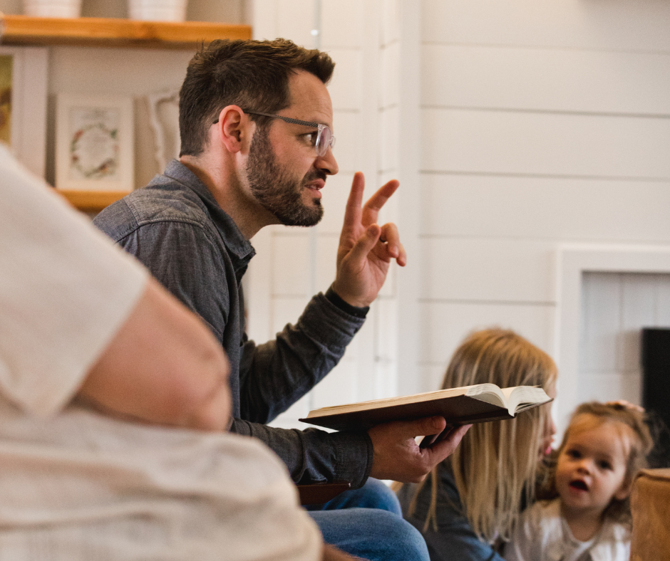 A pastor teaching a small group of people in a living room.