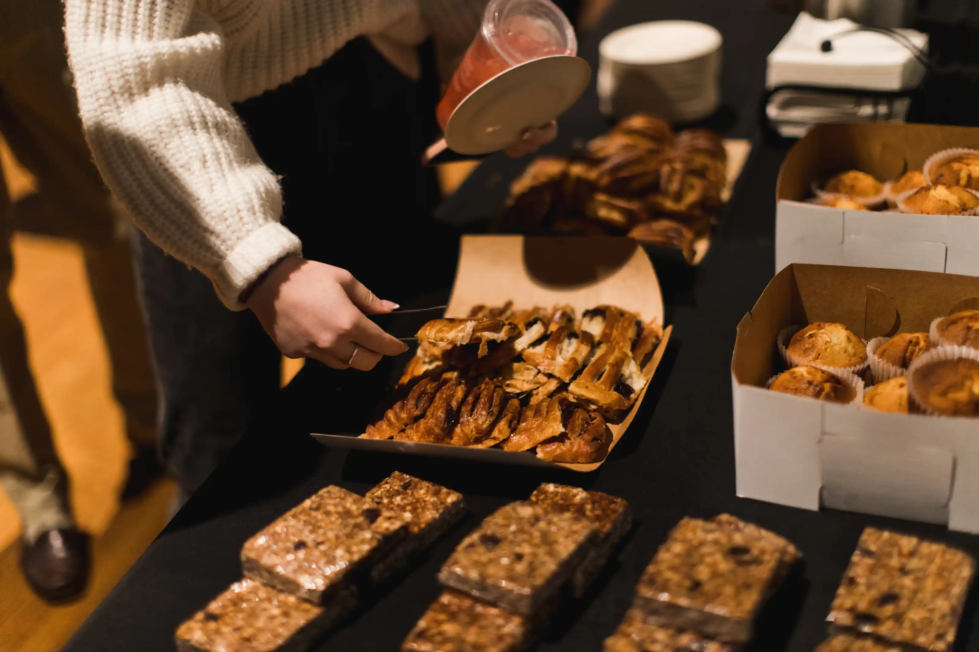 Closeup of a person's hands serving pastries on a Sunday morning.