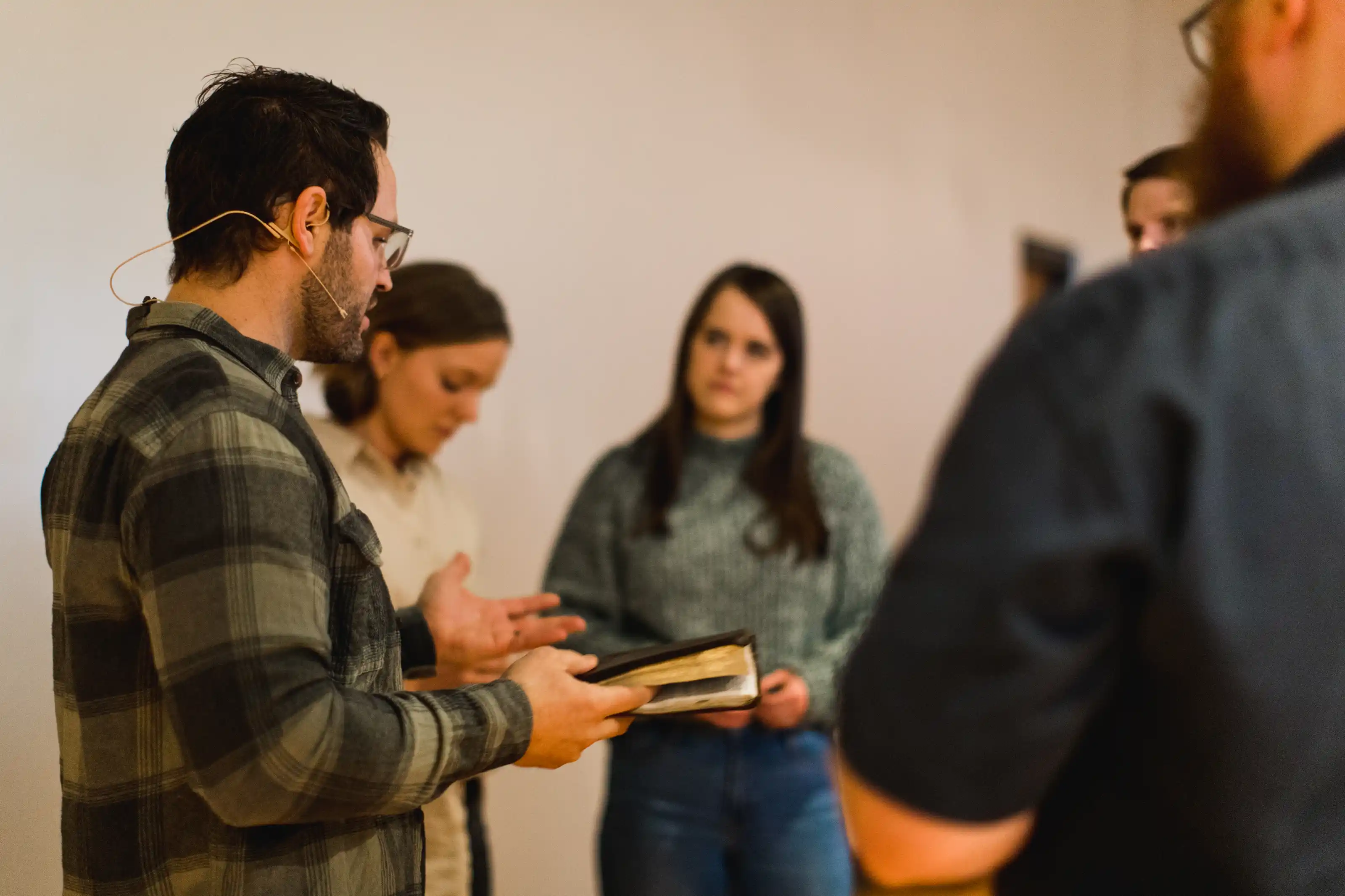 An older woman dancing playfully with a elementary school girl in a kitchen during small group.