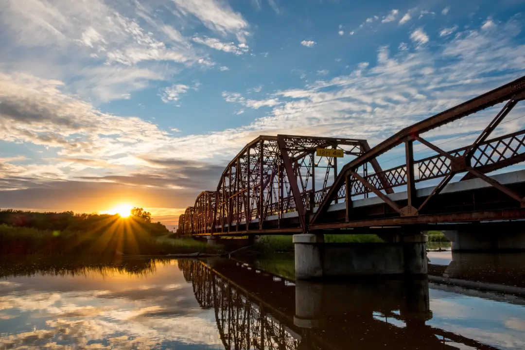 A bridge over an Oklahoma river at sunset.