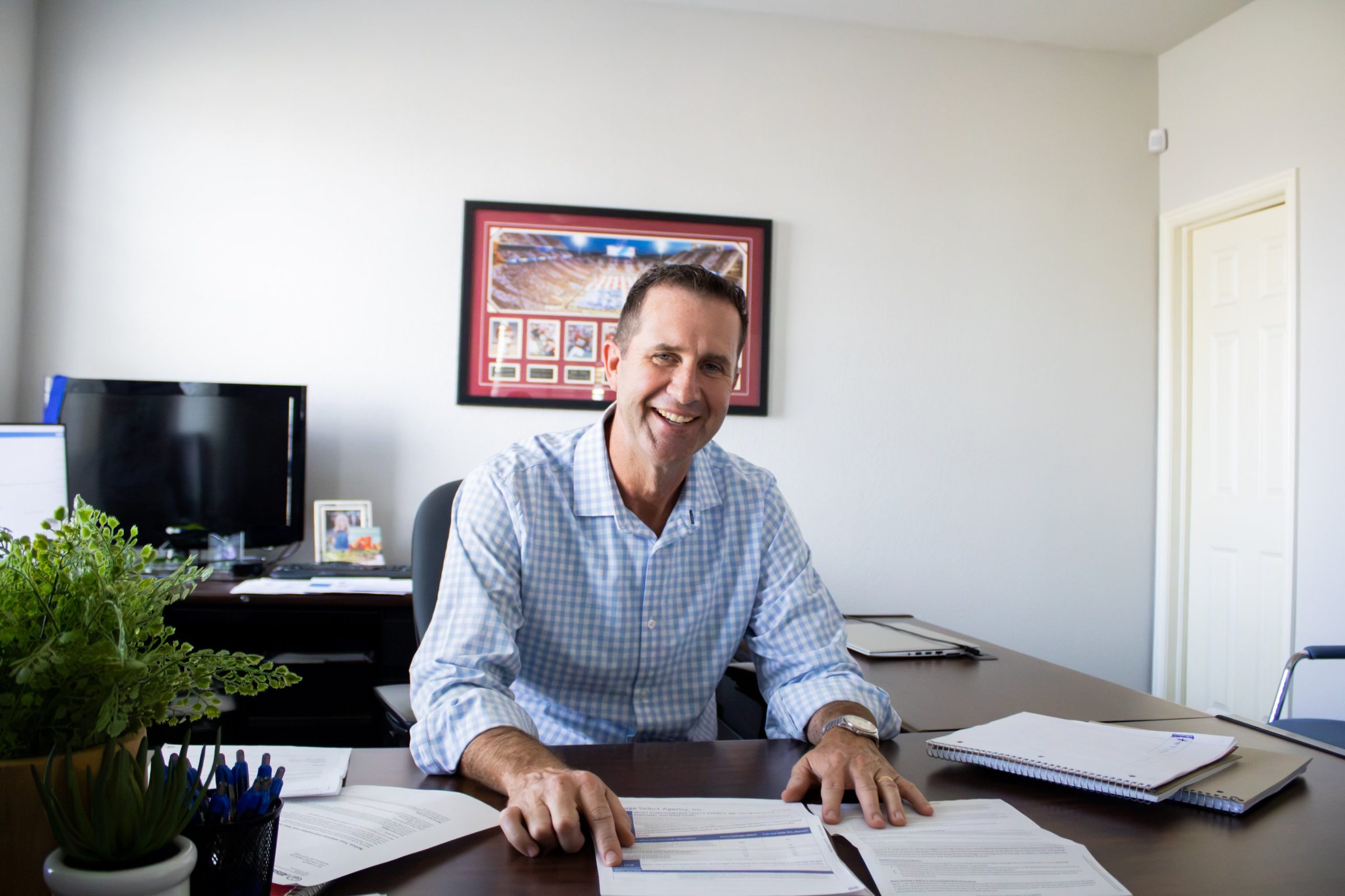 Josh Nelson smiling at his desk in his Norman, OK insurance office