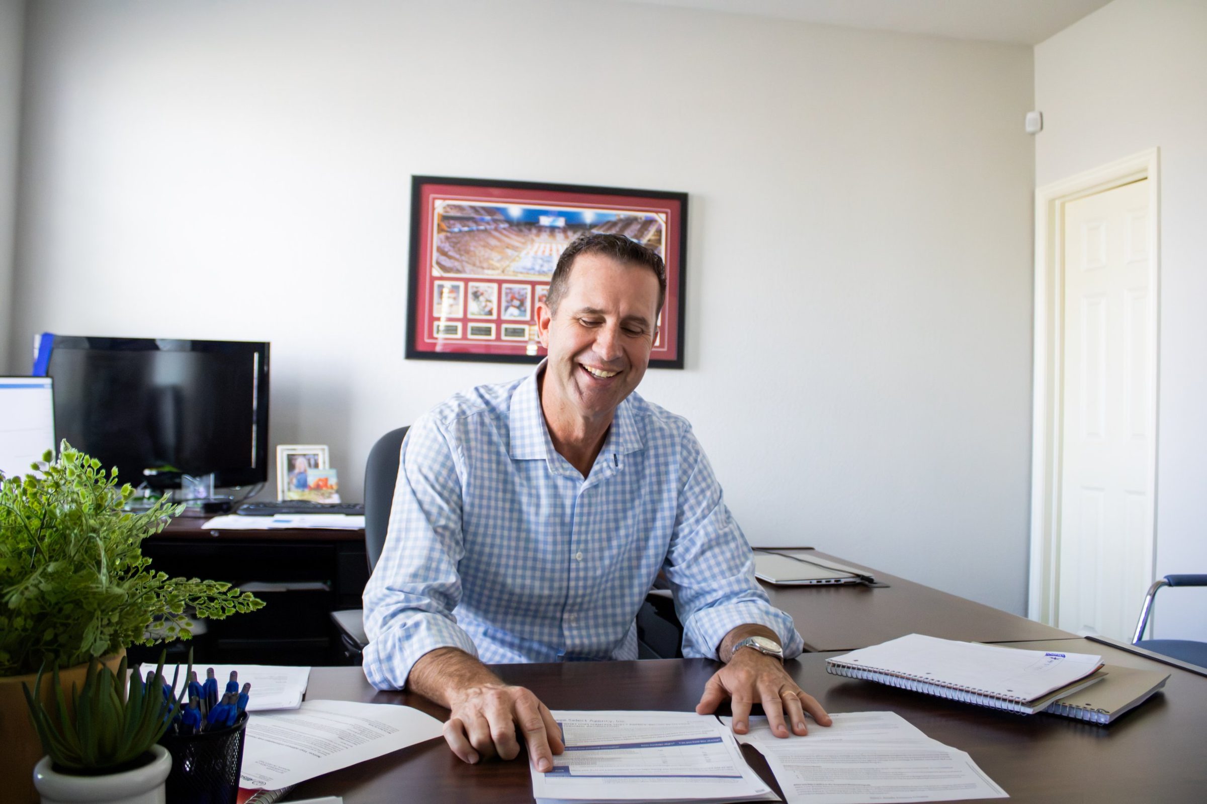 Josh Nelson reviewing home and auto insurance paperwork at his desk