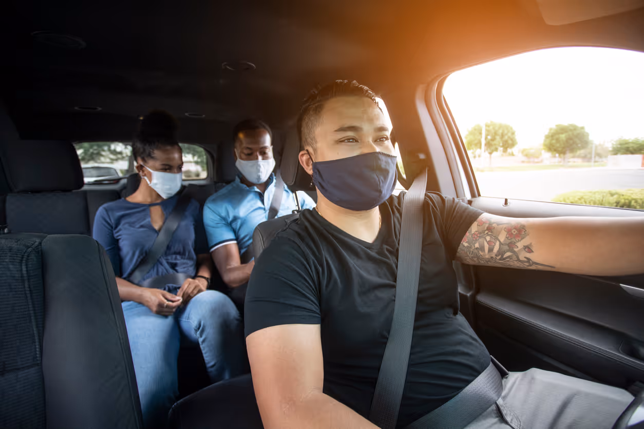 Rideshare passengers looking at a phone in the back of a car
