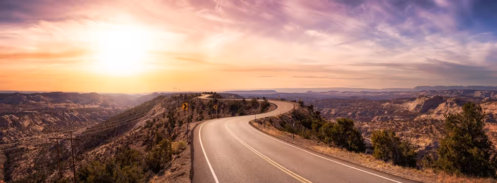Sunset over rolling hills with a highway