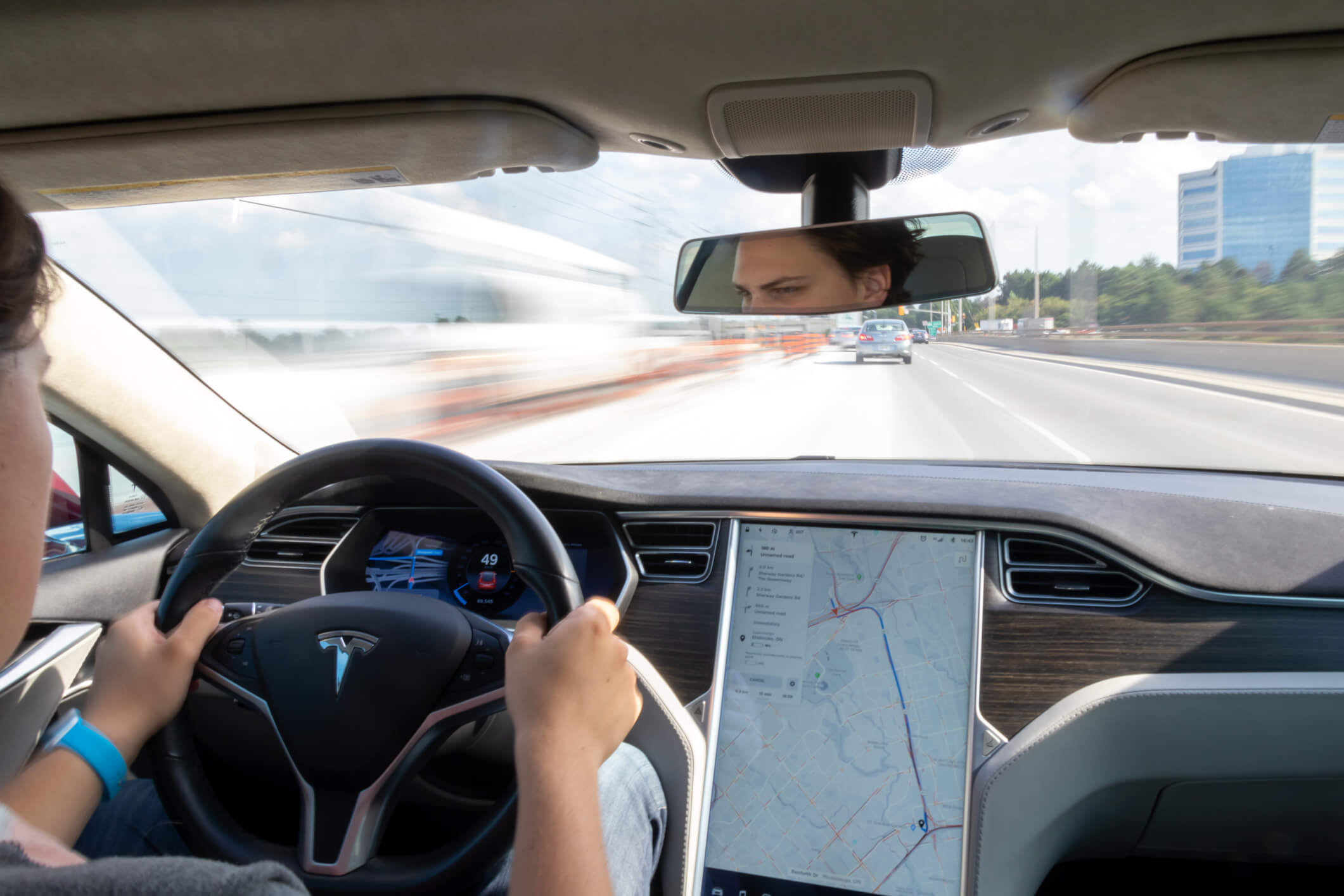 Stock image of person driving a Tesla