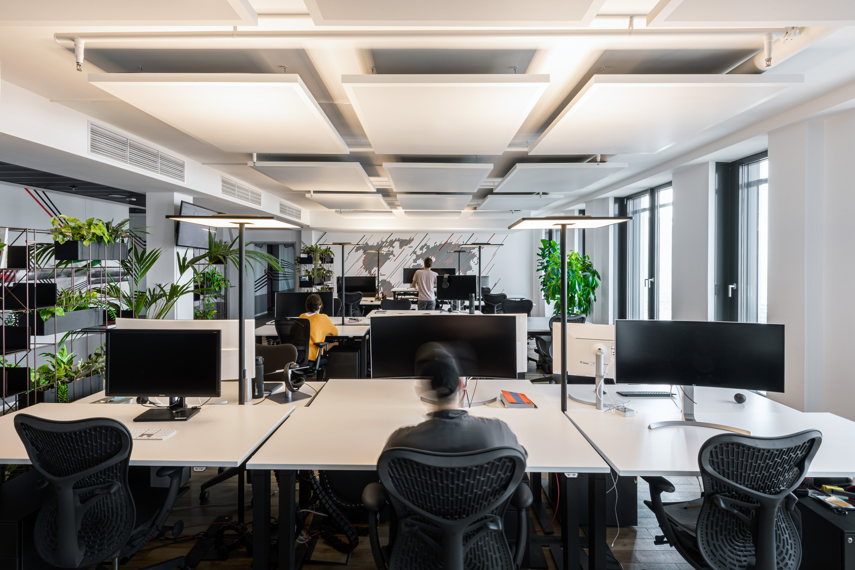 Große Büroraum mit Blick auf die Arbeitsplätze und der Weltkartengrafik an der Wand