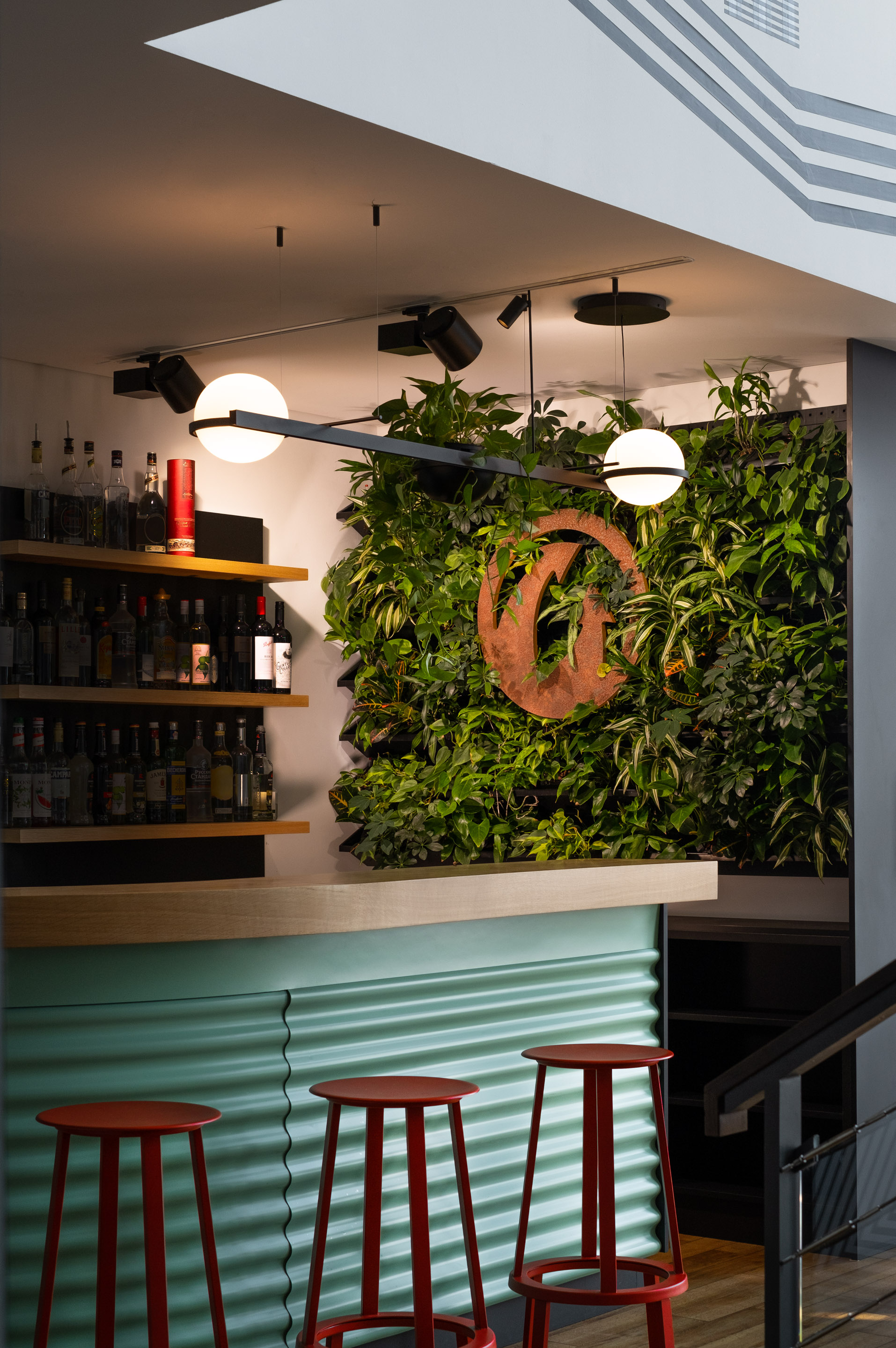 Grüne Wand an der Rezeption mit dem Firmenlogo in der Mitte