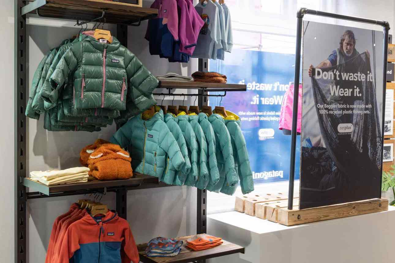 Patagonia store display with outdoor apparel and plants