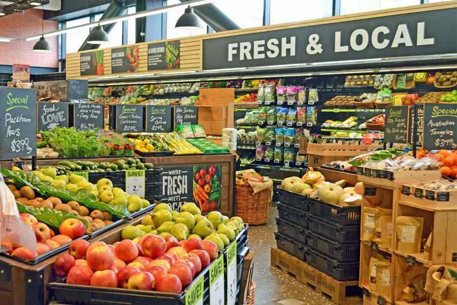 Supermarket produce display promoting fresh local products