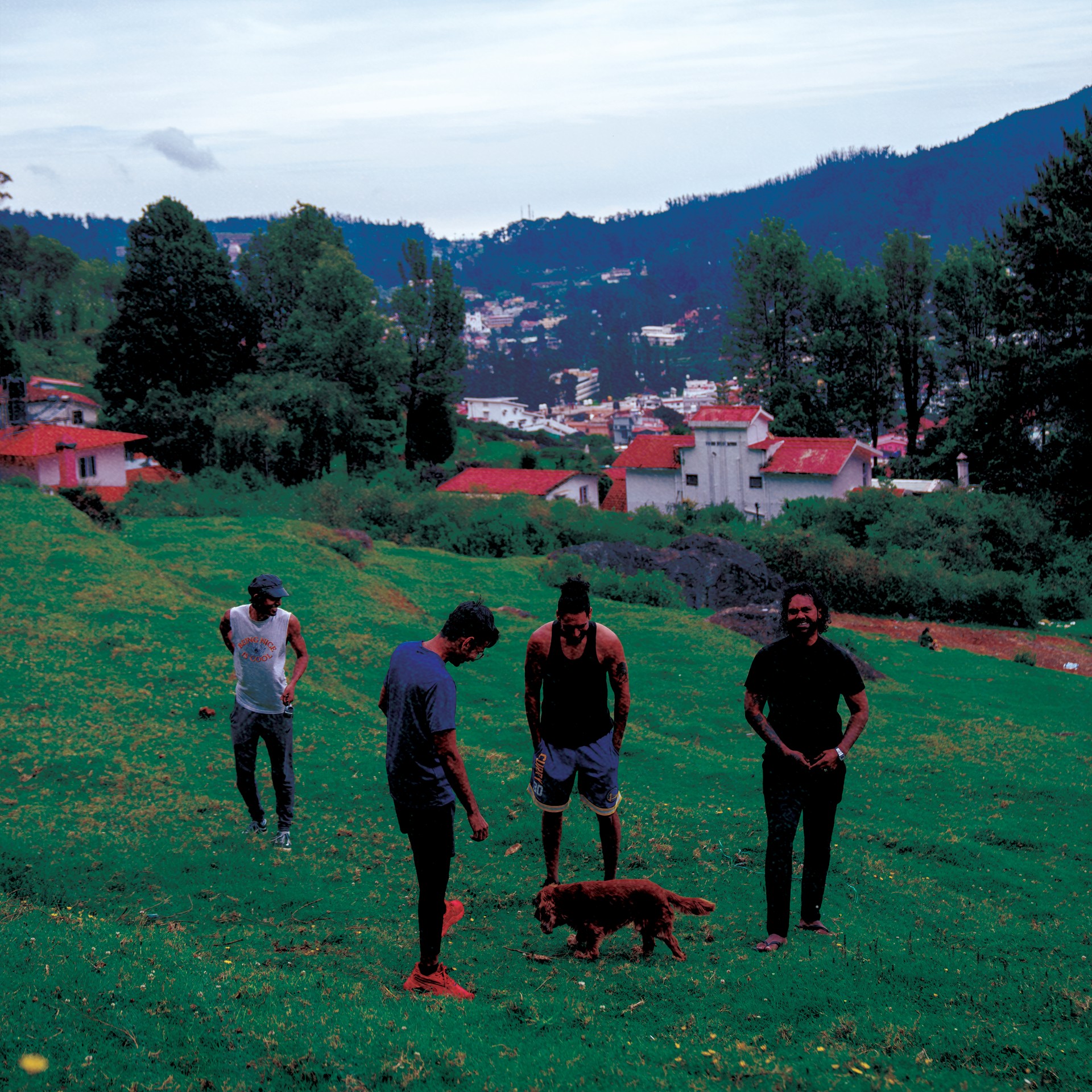 The band walking on a hillside with a dog
