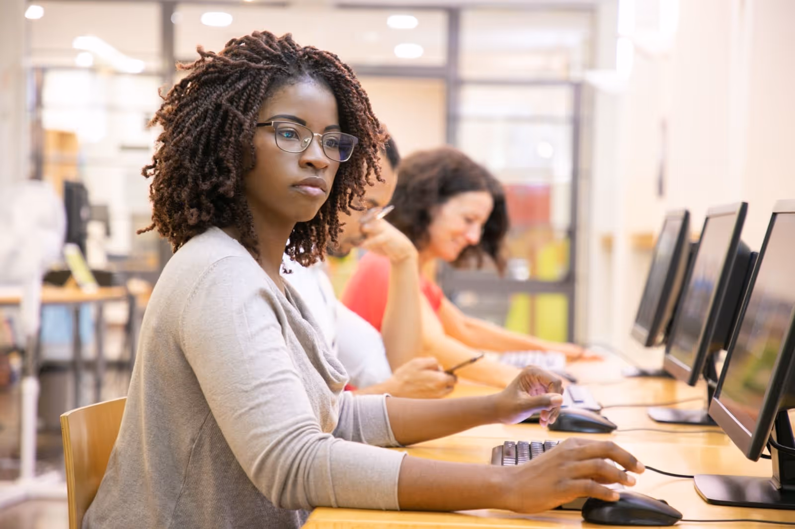 Serious student using a desktop computer in a classroom
