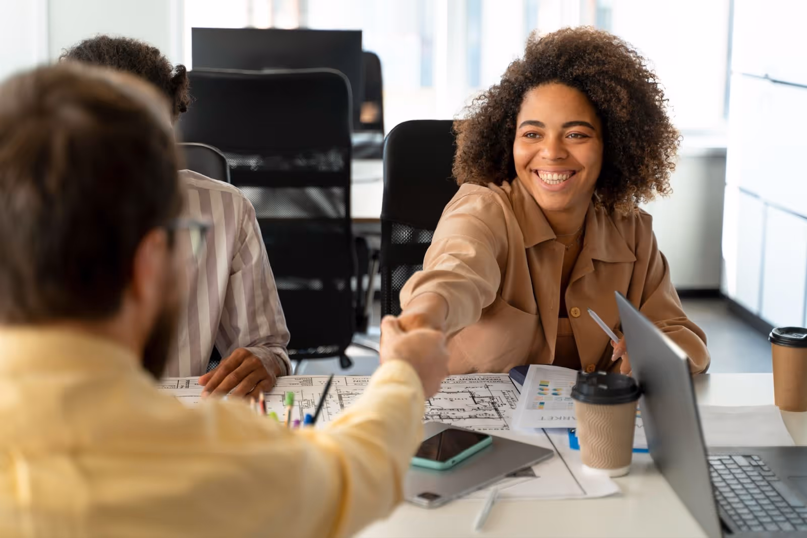 Smiling woman shaking hands during a meeting in office