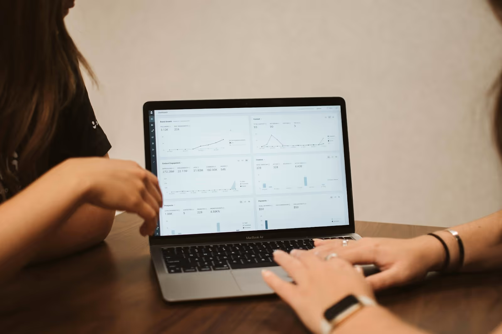 Two people analyzing data on a laptop screen