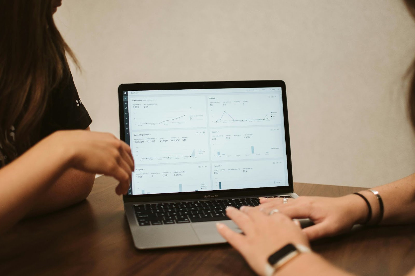 Two people analyzing data on a laptop screen