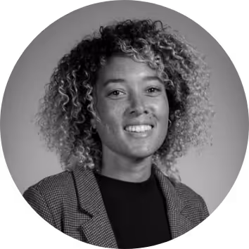 Smiling woman with curly hair in a checked blazer, portrait