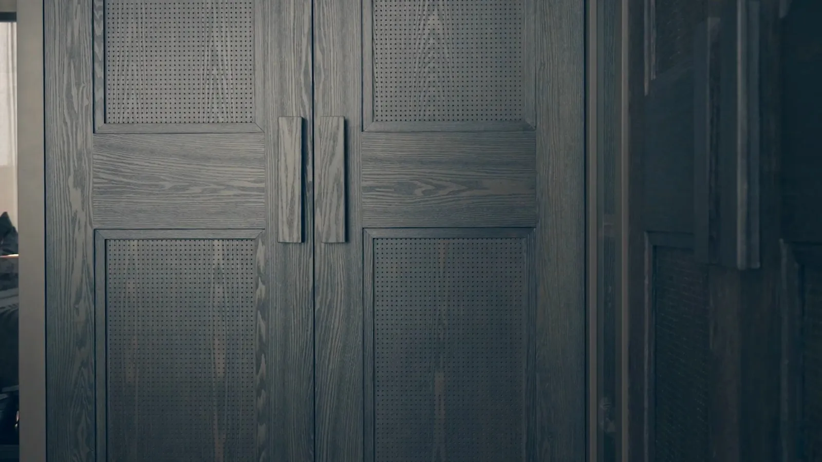 Dark wood cabinet doors with vertical handles and perforated wood panel inserts.