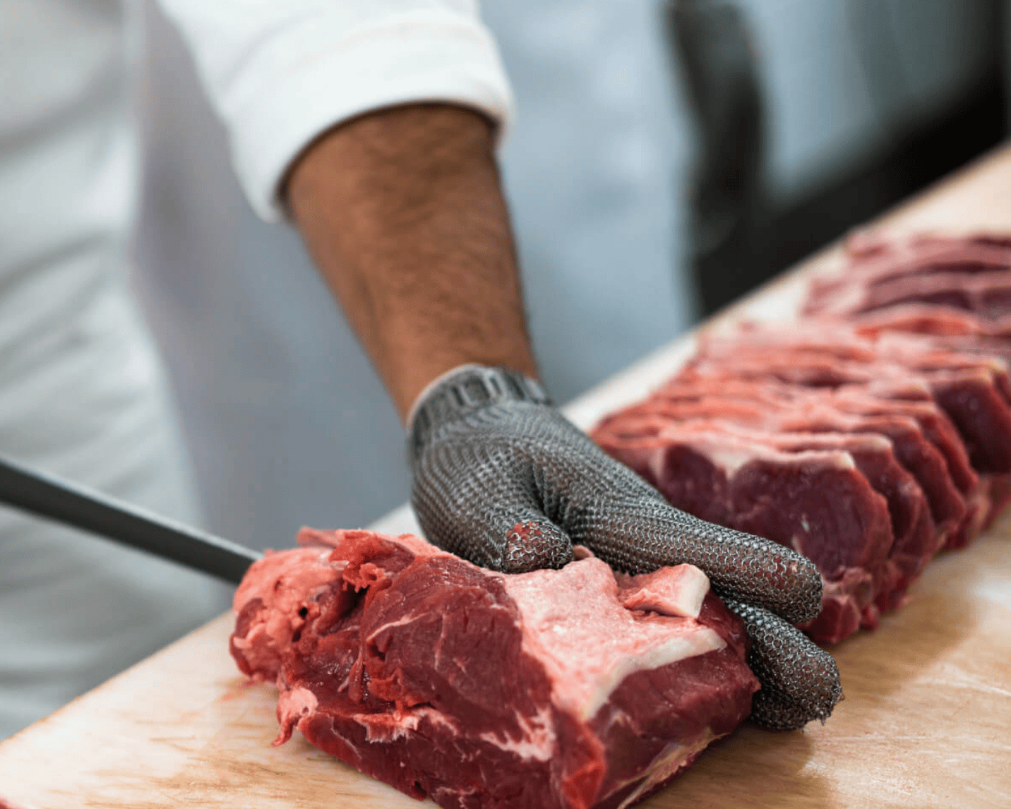 man cutting up meat- best butcher shop in dallas
