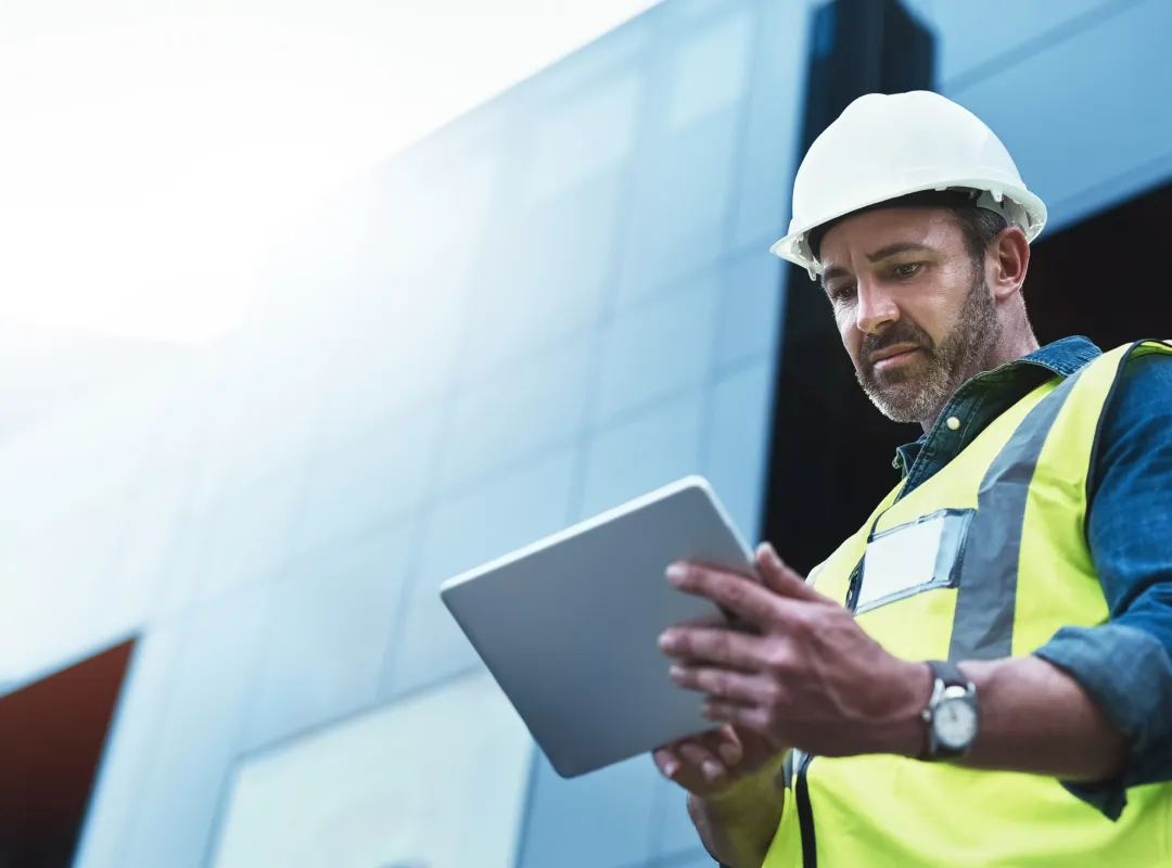 Male construction worker looking at tablet