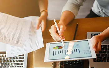 a facilities manager compares data stored digitally to a printed report